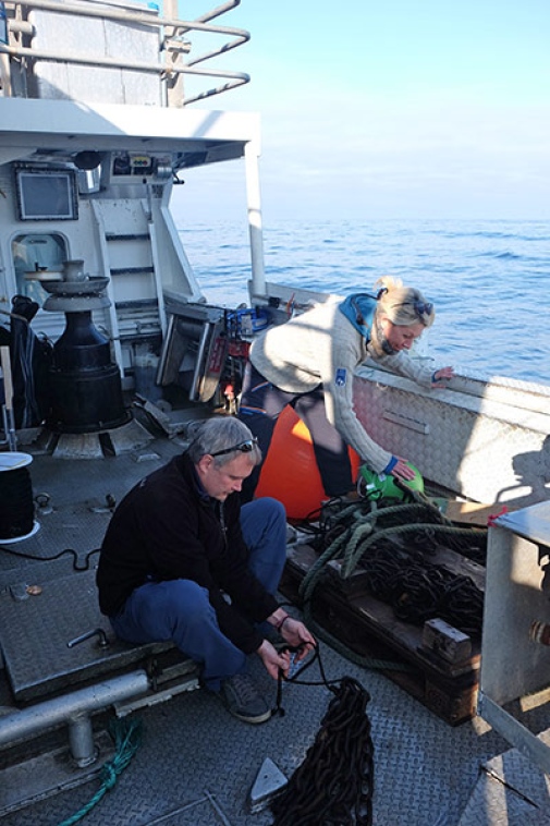 two scientist preparing the buoys on the boat